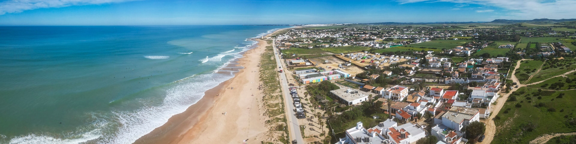 Un pueblo costero con playa, casas y cielo despejado.