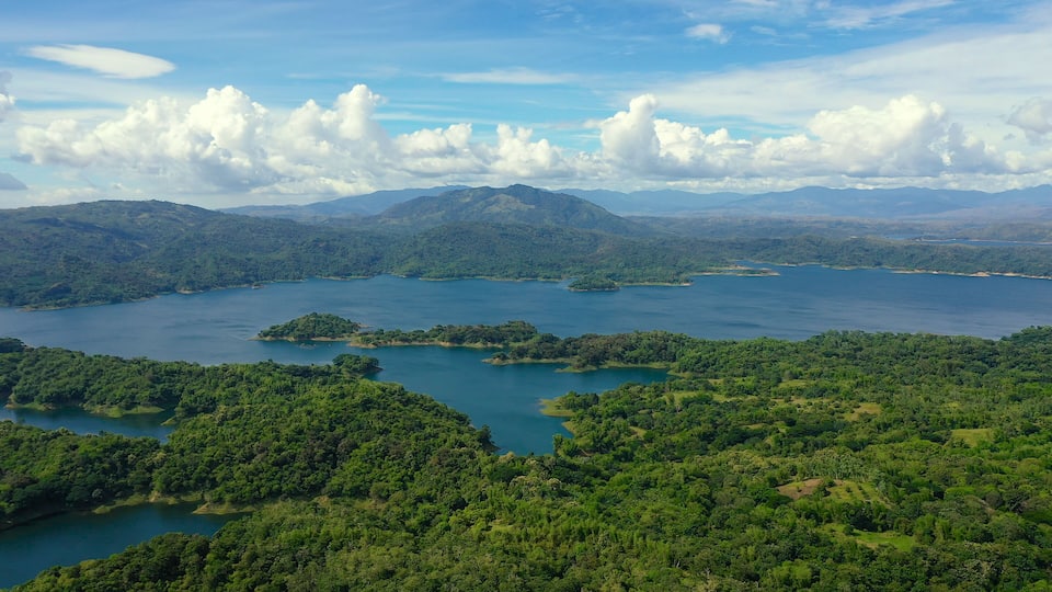 A lake surrounded by lush green hills and mountains.