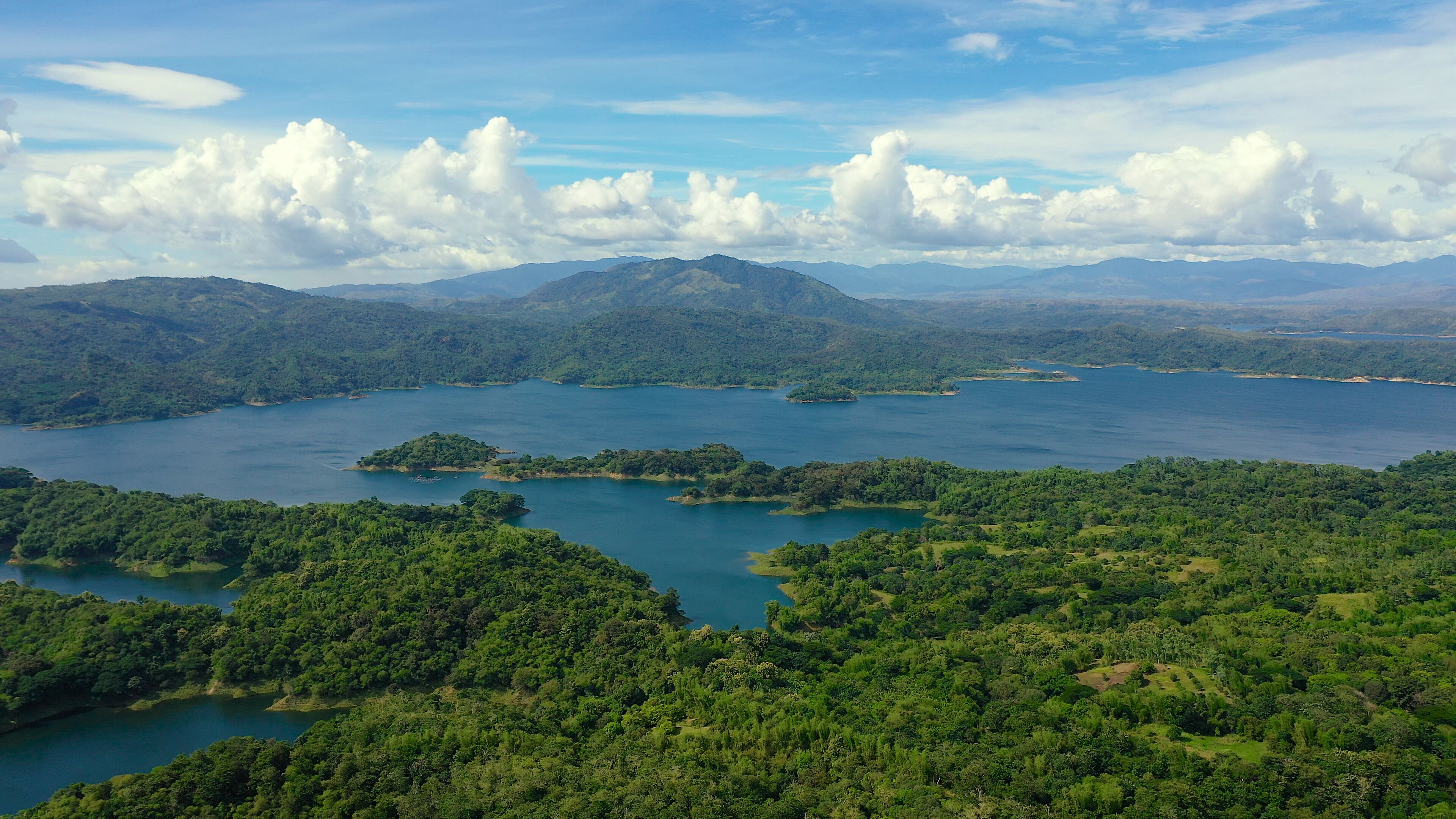 A lake surrounded by lush green hills and mountains.