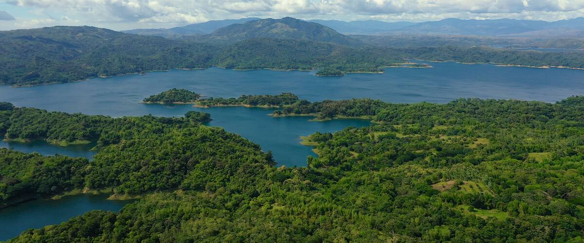 A lake surrounded by lush green hills and mountains.