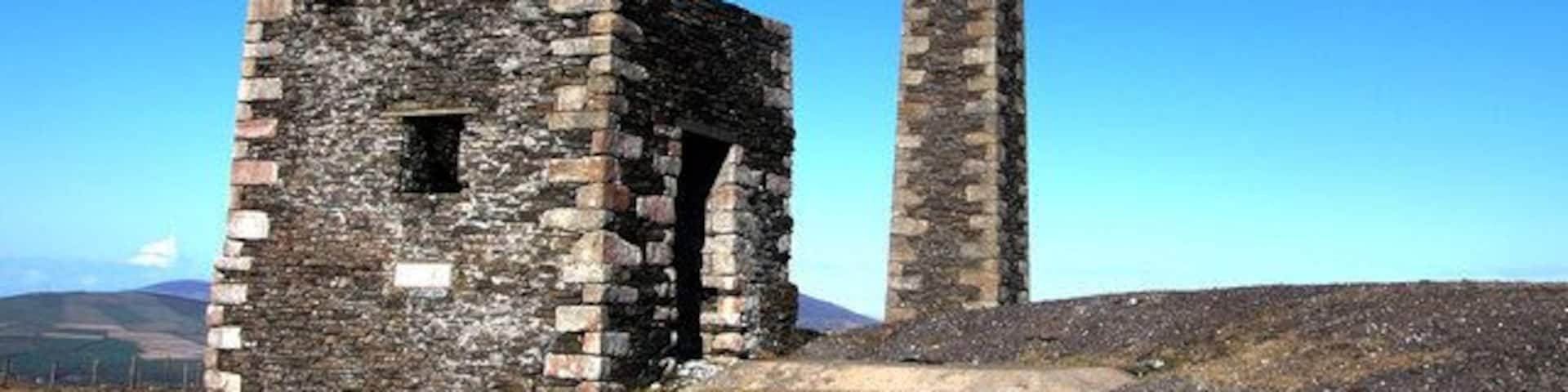 A stone ruin with a tall chimney.