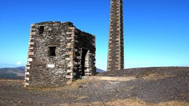 Ruinas de piedra con una chimenea alta.