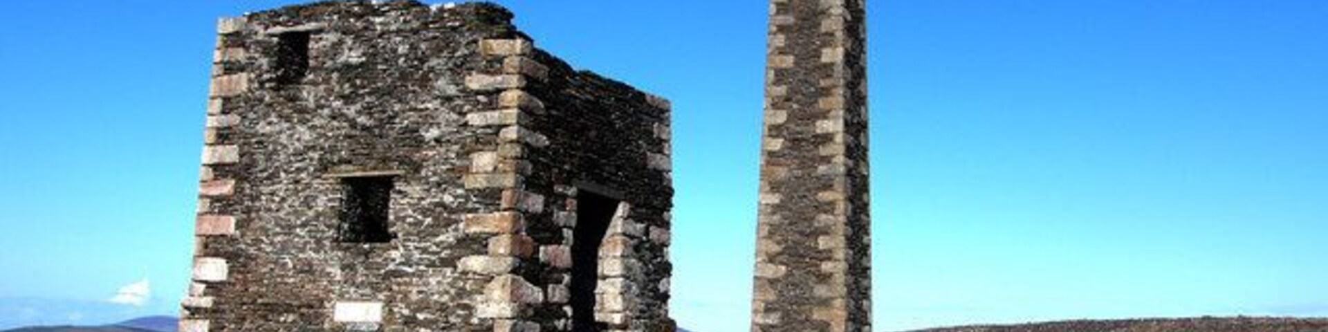 Ruinas de piedra con una chimenea alta.