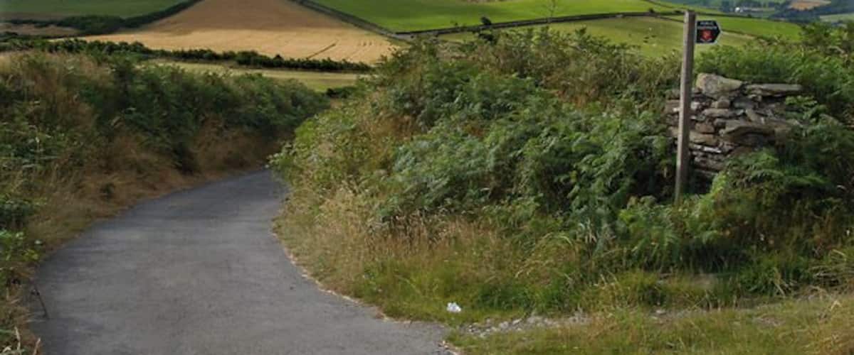 Cronk ny Moghlane from Cronk Breck. Isle of Man. The point where the old Cronk Breck to Bawshen road leaves the road leading to Lhargee Ruy. This road, like so many others, has now been downgraded to footpath status.