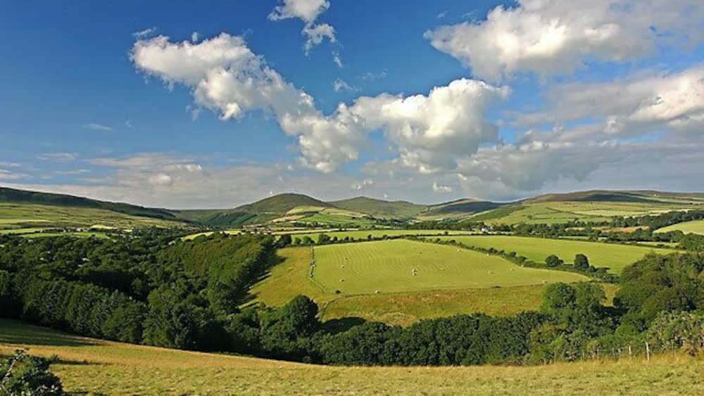 Baldwin. Looking NNE across the grid square on a lovely July evening, up the spur which runs from Carraghan. The valley of the River Glass on the left, Snaefell behind.