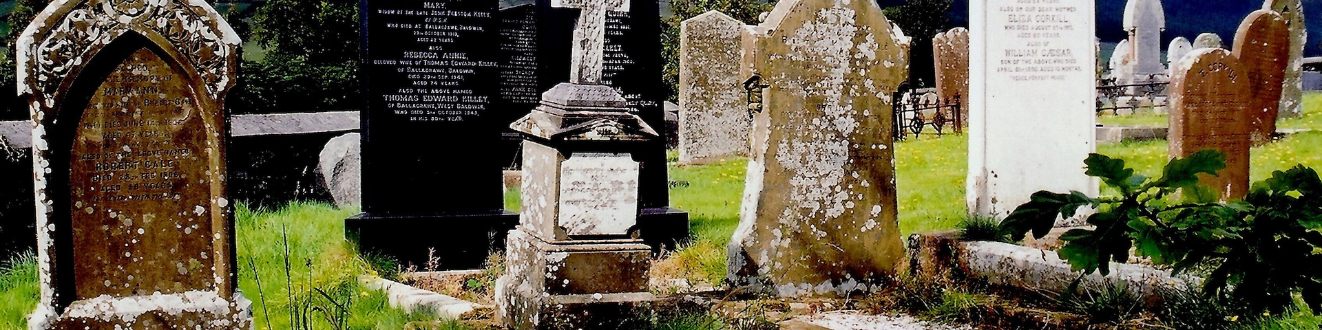 East Baldwin - St Luke's Church - Gravestones View is to the southwest from St Luke's Church graveyard towards B36. The lighting got my attention, as the gravestones were illuminated against the dark sky over the mountain in the background.