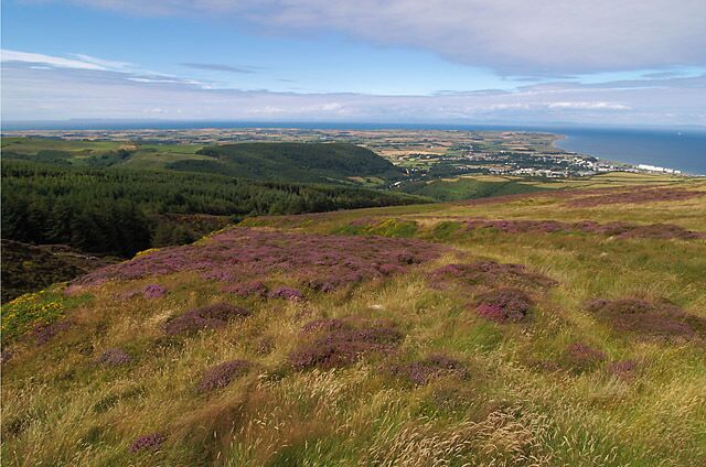 View from near Guthries Memorial. Isle of Man. You can see Brookdale Plantation (nearest, on the left) Skyhill Plantation (centre), the town of Ramsey , the northern plain stretching to the Point of Ayre and even the Scottish coastline.
