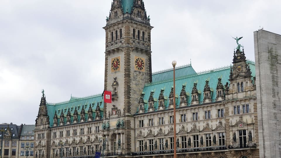 A historic building with a clock tower and a green roof.