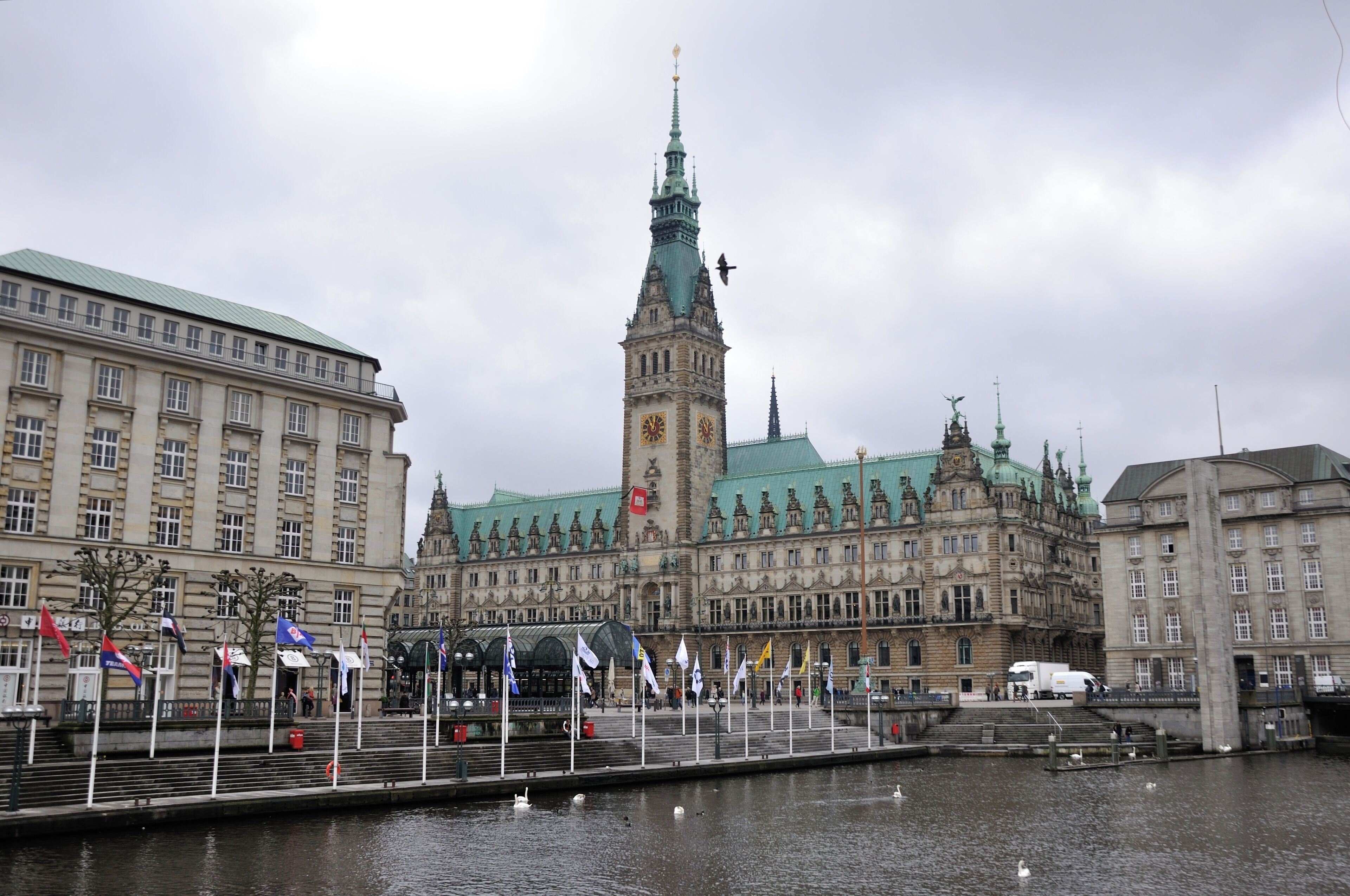 Un bâtiment historique doté d’un imposant clocher et avec une rivière en premier plan.