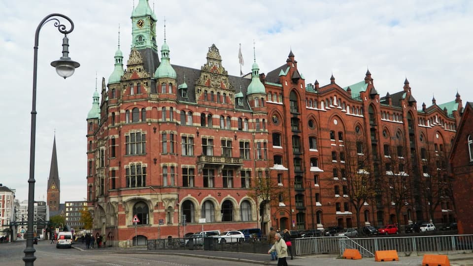 A historic red brick building with ornate architecture and a clock tower.