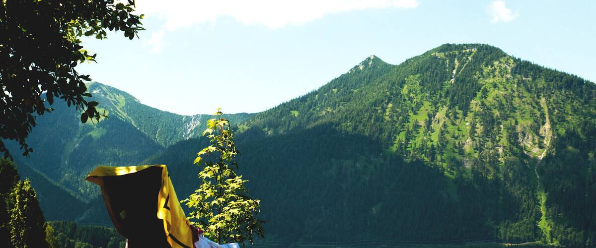 A chair by a lake with mountains in the background.