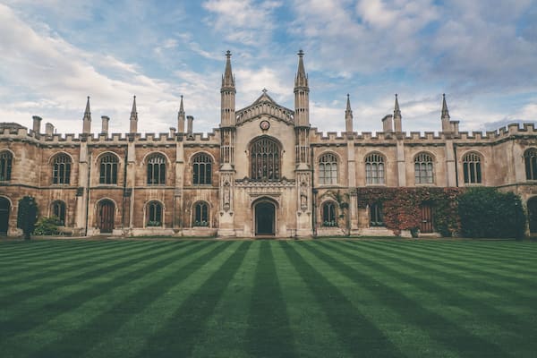 A large historic building with a symmetrical facade, tall spires, and a central clock tower.