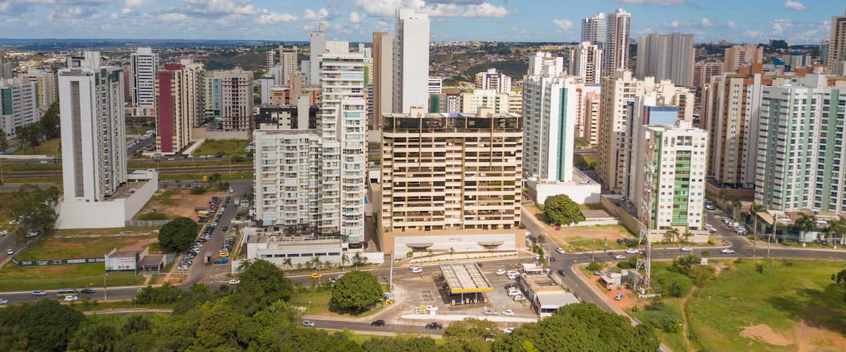 A cityscape with high-rise buildings, a parking lot, and a clear sky.