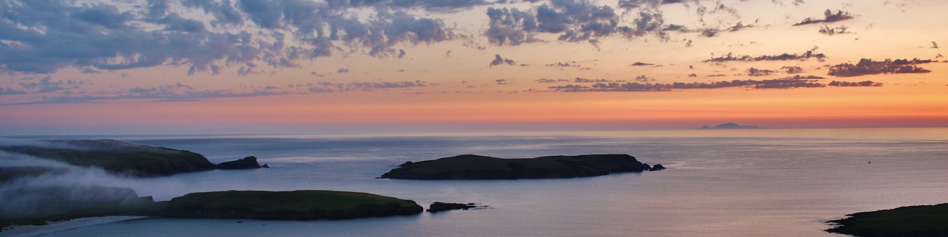 Looking out over the the small island of Colsa and distant Foula.