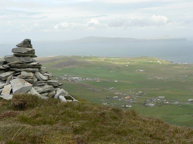 Cairn on Hoo Field This cairn sits on the edge of Hoo Field. The community of Cunningsburgh lies below.