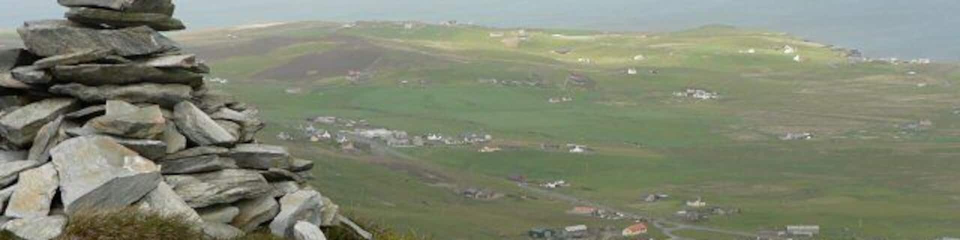 Cairn on Hoo Field This cairn sits on the edge of Hoo Field. The community of Cunningsburgh lies below.