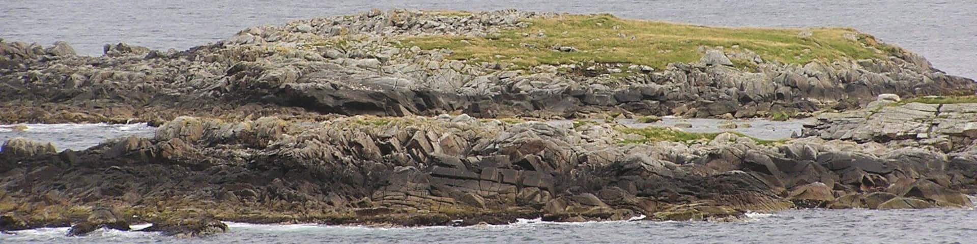 Atla Holm As seen from Fugla Ness on Burra. In the foreground is Scarva Taing with Green Holm HU3837 in the distance.