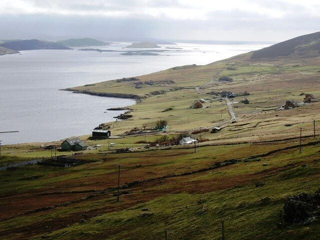 Cott, Weisdale Voe, Shetland. Looking south across the community of Cott on the east side of Russaness Hill and down Weisdale Voe with the islands of Greena, Flotta and the Hoggs of Hoy in the distance.