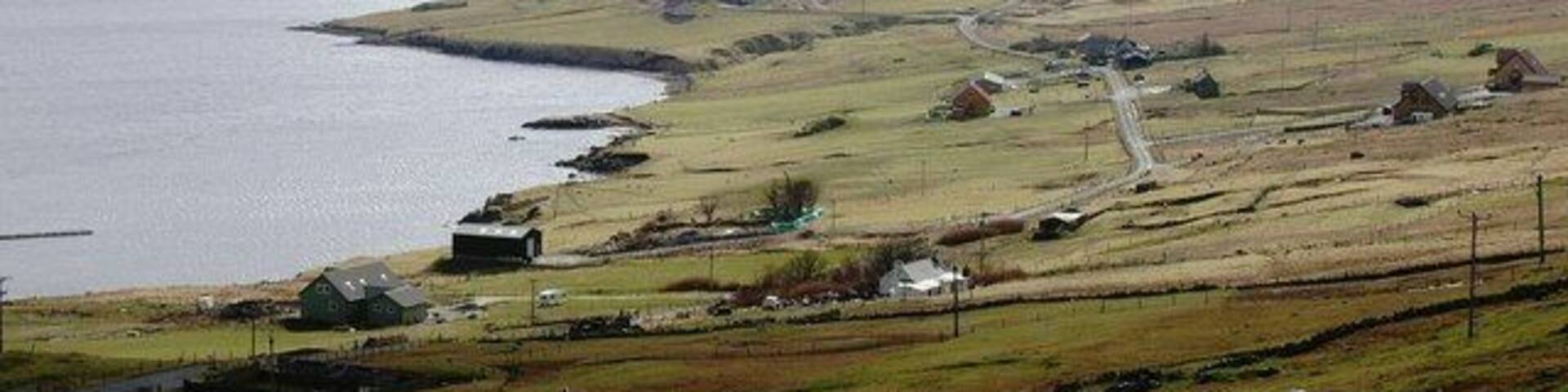 Cott, Weisdale Voe, Shetland. Looking south across the community of Cott on the east side of Russaness Hill and down Weisdale Voe with the islands of Greena, Flotta and the Hoggs of Hoy in the distance.