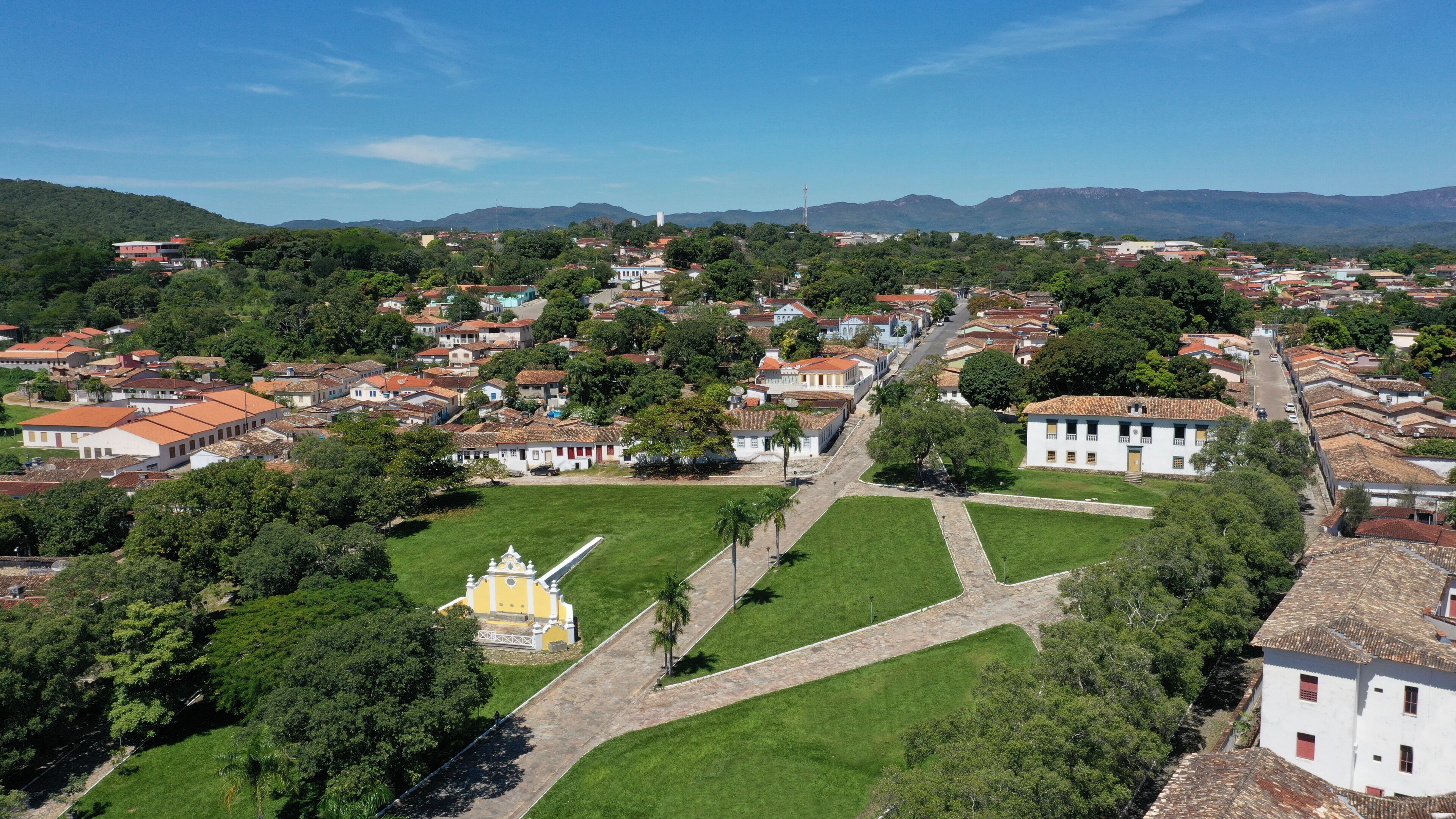 A town with a central square, surrounded by buildings and greenery.