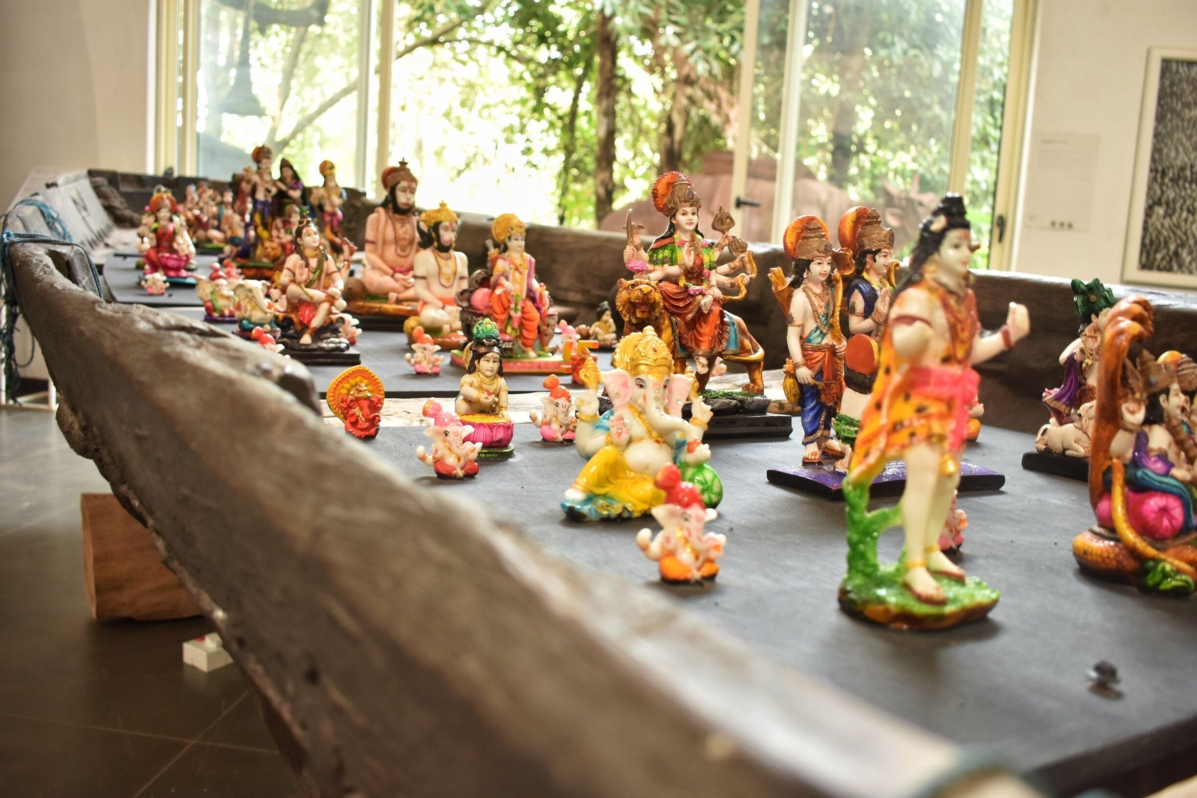 A collection of colorful statues arranged on a wooden platform.