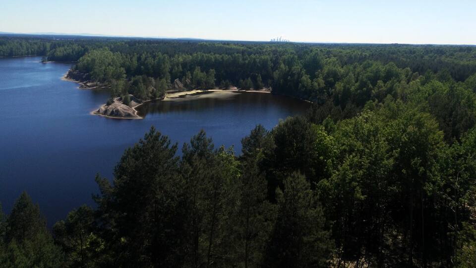 A lake surrounded by dense forest and rocky outcrops.