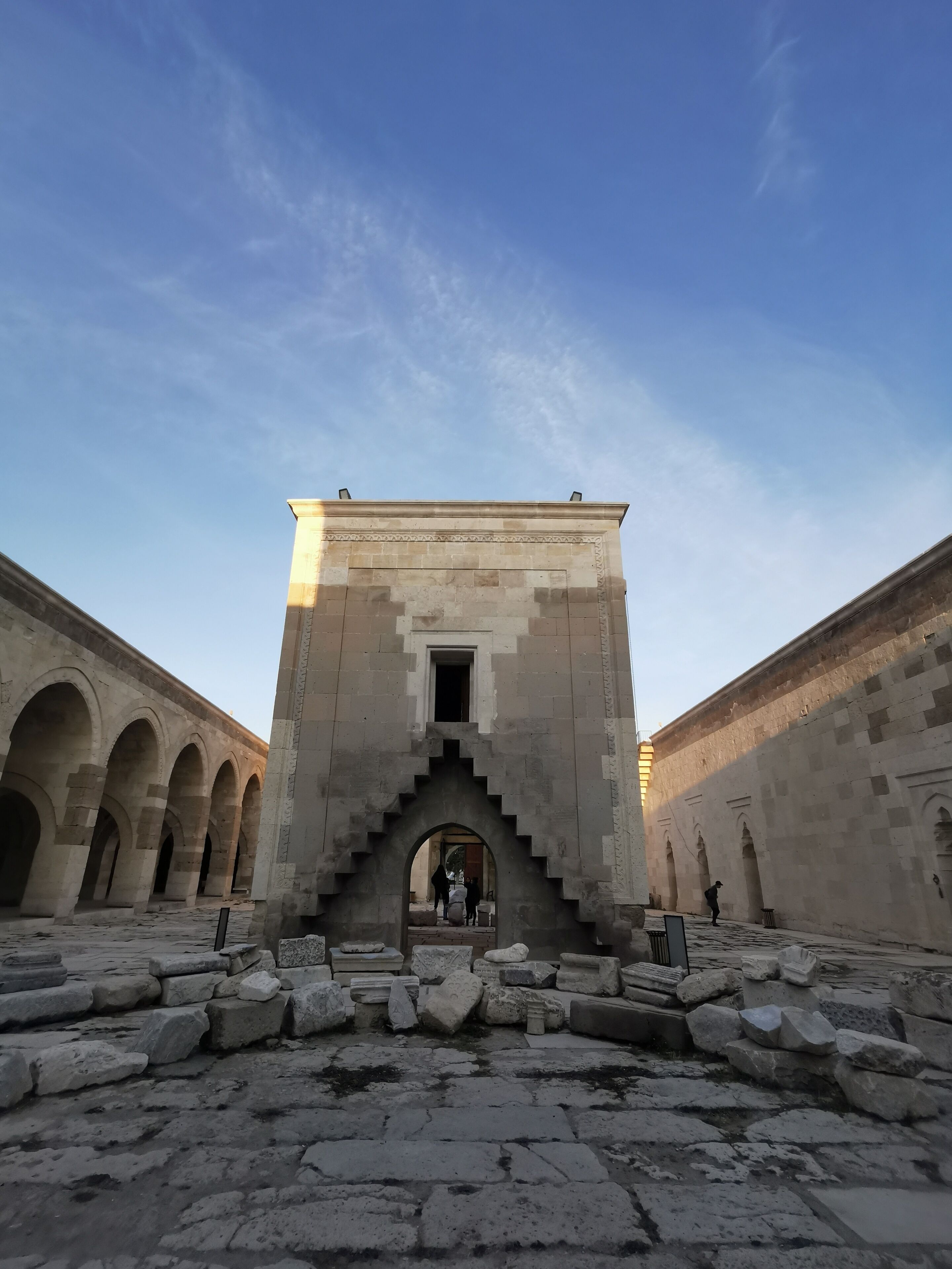 A historical building with a central staircase and arched corridors.