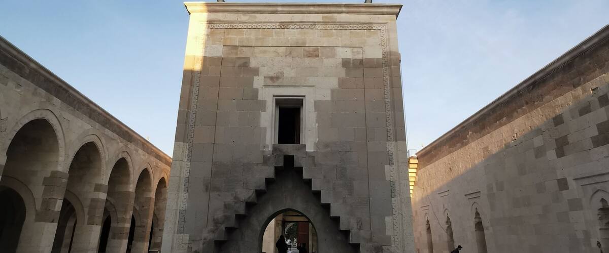 A historical building with a central staircase and arched corridors.
