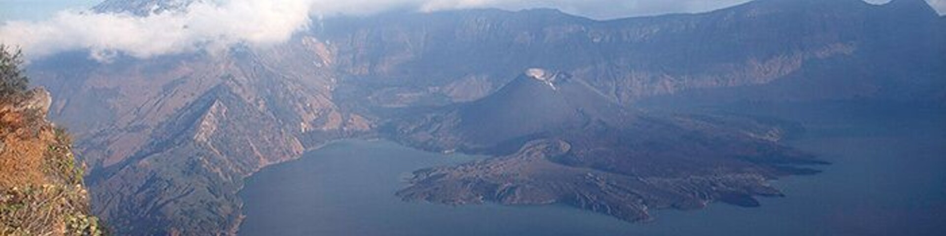 Un paisaje montañoso con un lago y un volcán.