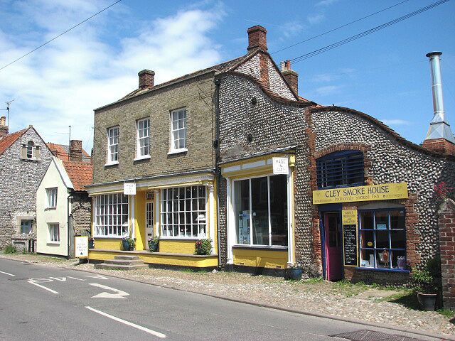 Made in Cley. Starr House, dating from the mid-19th century, presently houses a pottery and gift shop. Adjoining it is > 841647. Present-day Cley is not in the same location as the medieval village of Cley used to be. This was located south of St Margaret's church > https://www.geograph.org.uk/photo/309410 and had a busy harbour, which was ruined by embanking in the 1640s by Sir Henry Calthorpe. A fire had already encouraged relocation in 1612. When Thomas Telford had been called in, in 1822, to advise on the problem of silting the Cley channel, his advice was ignored and the once busy port is now history. Many of the houses and cottages that line the narrow High Street (A149) through the village are built from flint and brick and date from the 17th and 18th centuries.