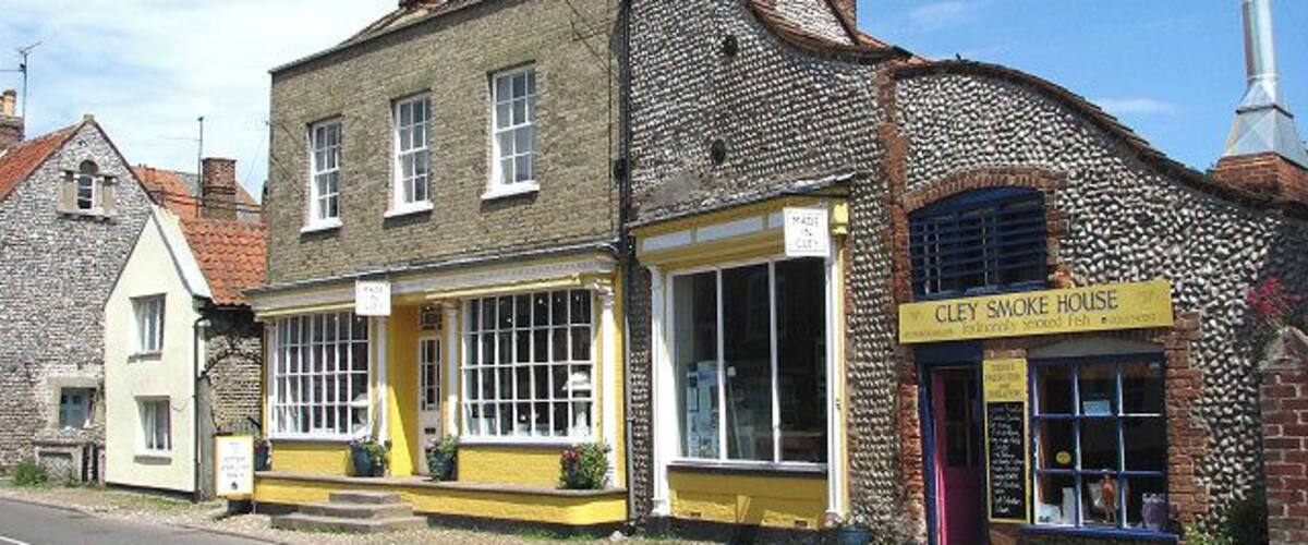 Made in Cley. Starr House, dating from the mid-19th century, presently houses a pottery and gift shop. Adjoining it is > 841647. Present-day Cley is not in the same location as the medieval village of Cley used to be. This was located south of St Margaret's church > https://www.geograph.org.uk/photo/309410 and had a busy harbour, which was ruined by embanking in the 1640s by Sir Henry Calthorpe. A fire had already encouraged relocation in 1612. When Thomas Telford had been called in, in 1822, to advise on the problem of silting the Cley channel, his advice was ignored and the once busy port is now history. Many of the houses and cottages that line the narrow High Street (A149) through the village are built from flint and brick and date from the 17th and 18th centuries.