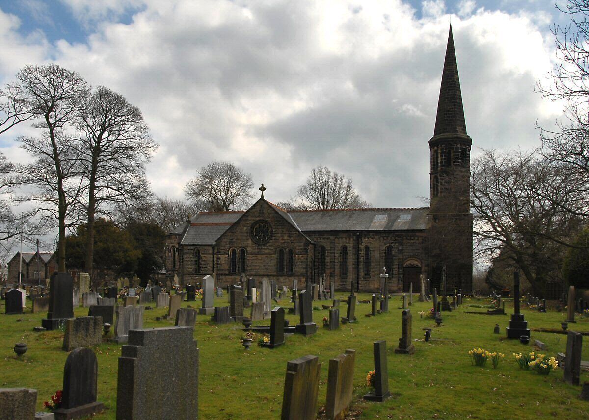 A church with a tall spire and a graveyard with numerous headstones.