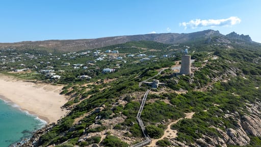 A coastal town with a lighthouse, beach, and hilly terrain.