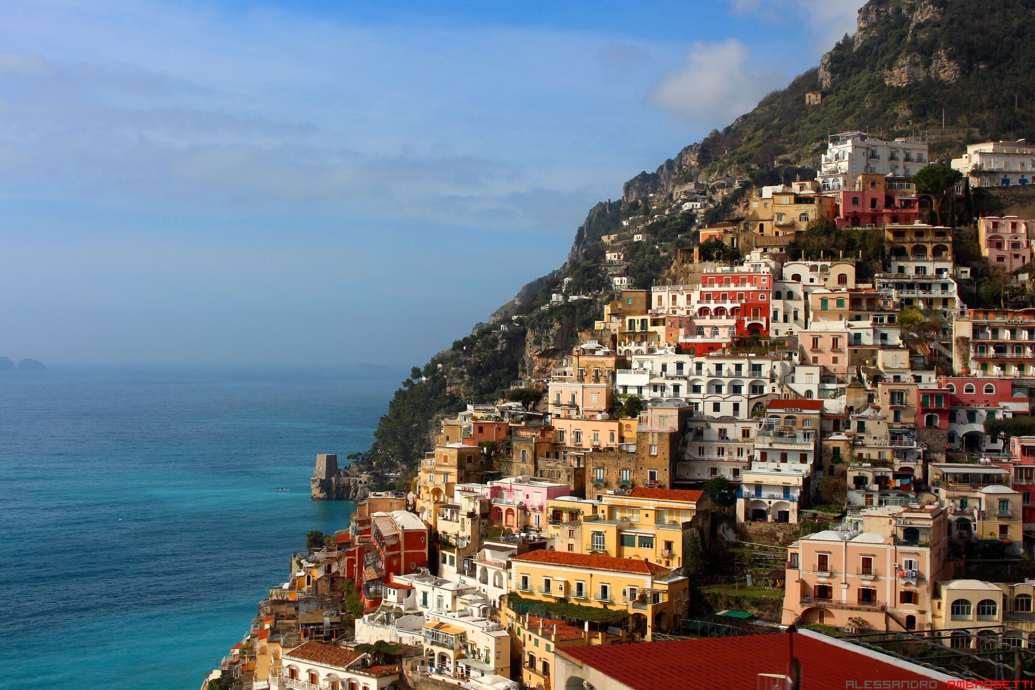 A coastal town with colorful buildings perched on a hillside overlooking the sea.