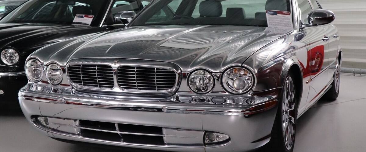 A classic car with a chrome grille and round headlights in a showroom.