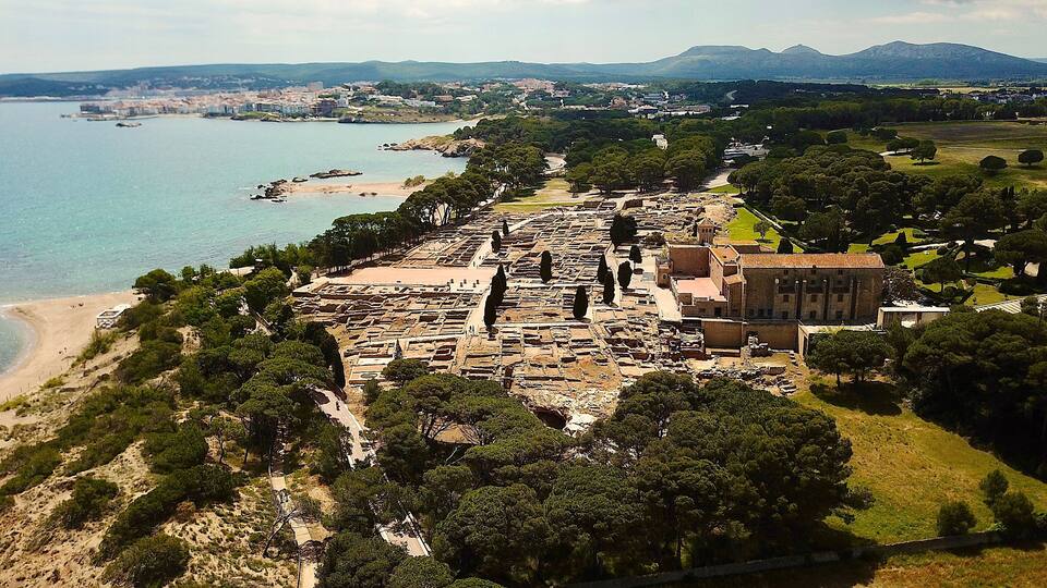 An ancient archaeological site with ruins and a beach.