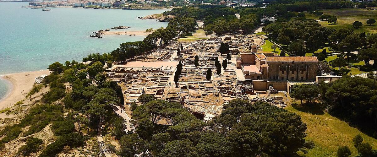 An ancient archaeological site with ruins and a beach.
