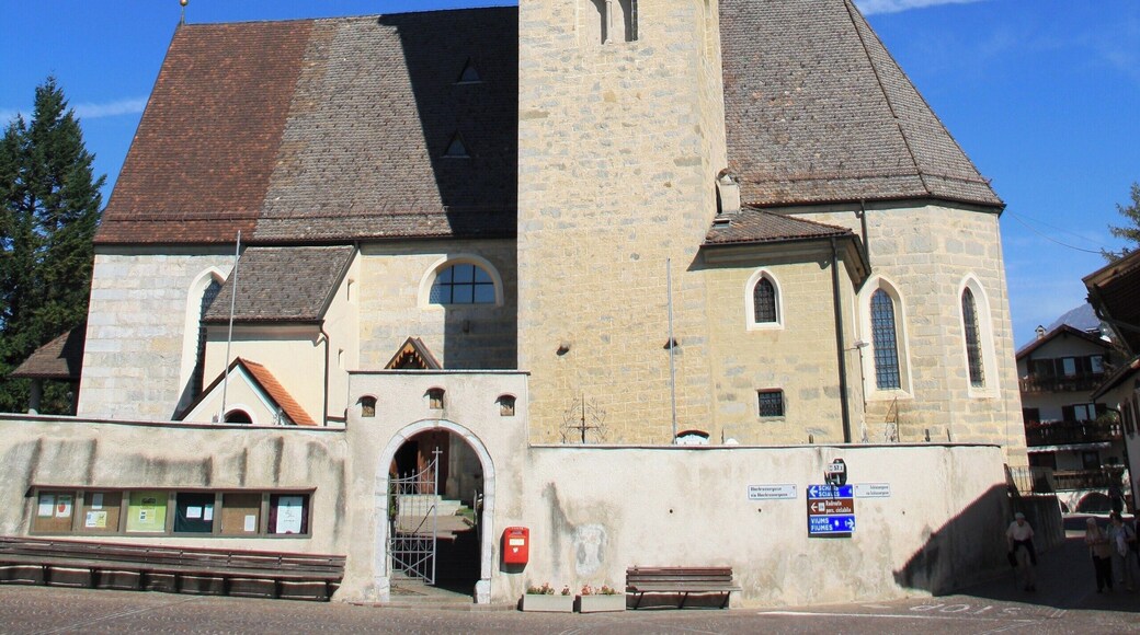 Italy, South Tirol, Natz-Schabs, Schlossergasse, Pfarrkirche Hll. Aposteln Philippus und Jakobus. The first mention of the parish church in Natz dates back to 1157 but the church was consecrated in 1208 by the prince-bishop Konrad von Rodank in honour of Saint Philip and Saint Walpurga. The present church was completed in 1484 in Late Gothic and consecrated once again to the Saints Apostles Philip and James. The bell tower was built in 1400 with granite blocks; in 1635 was damaged by fire and in 1686 was covered with a dome in Baroque style. The high altar is work by Peter Lapper of Natz made in 1855. In the throne of the high altar are the statue of the Madonna, Saint Agnes and Saint Ursula which are Gothc works of 1499 attributed to Michael Parcher; the statues of St. Philip and St. James are by F. X. Renn of Imst made in 1857. The painting of the right lateral altar represent the Baptism of Jesus and the left side altar correspond to the Holy Family, both works are by Michael Lackner of Bruneck. The first organ was installed on May 1st, 1909; the present one has been built by Orgelbau Pirchner of Steinach am Brenner and has 16 registers and 1250 pipes and was inaugurated on May 1st, 1990.