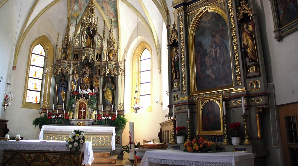 Italy, South Tirol, Natz-Schabs, Schlossergasse, Pfarrkirche Hll. Aposteln Philippus und Jakobus. The first mention of the parish church in Natz dates back to 1157 but the church was consecrated in 1208 by the prince-bishop Konrad von Rodank in honour of Saint Philip and Saint Walpurga. The present church was completed in 1484 in Late Gothic and consecrated once again to the Saints Apostles Philip and James. The bell tower was built in 1400 with granite blocks; in 1635 was damaged by fire and in 1686 was covered with a dome in Baroque style. The high altar is work by Peter Lapper of Natz made in 1855. In the throne of the high altar are the statue of the Madonna, Saint Agnes and Saint Ursula which are Gothc works of 1499 attributed to Michael Parcher; the statues of St. Philip and St. James are by F. X. Renn of Imst made in 1857. The painting of the right lateral altar represent the Baptism of Jesus and the left side altar correspond to the Holy Family, both works are by Michael Lackner of Bruneck. The first organ was installed on May 1st, 1909; the present one has been built by Orgelbau Pirchner of Steinach am Brenner and has 16 registers and 1250 pipes and was inaugurated on May 1st, 1990.