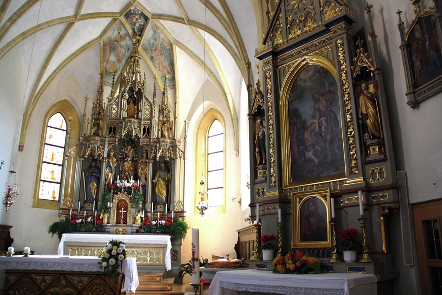 Italy, South Tirol, Natz-Schabs, Schlossergasse, Pfarrkirche Hll. Aposteln Philippus und Jakobus. The first mention of the parish church in Natz dates back to 1157 but the church was consecrated in 1208 by the prince-bishop Konrad von Rodank in honour of Saint Philip and Saint Walpurga. The present church was completed in 1484 in Late Gothic and consecrated once again to the Saints Apostles Philip and James. The bell tower was built in 1400 with granite blocks; in 1635 was damaged by fire and in 1686 was covered with a dome in Baroque style. The high altar is work by Peter Lapper of Natz made in 1855. In the throne of the high altar are the statue of the Madonna, Saint Agnes and Saint Ursula which are Gothc works of 1499 attributed to Michael Parcher; the statues of St. Philip and St. James are by F. X. Renn of Imst made in 1857. The painting of the right lateral altar represent the Baptism of Jesus and the left side altar correspond to the Holy Family, both works are by Michael Lackner of Bruneck. The first organ was installed on May 1st, 1909; the present one has been built by Orgelbau Pirchner of Steinach am Brenner and has 16 registers and 1250 pipes and was inaugurated on May 1st, 1990.