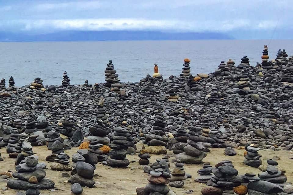 A rocky beach with stacks of stones.
