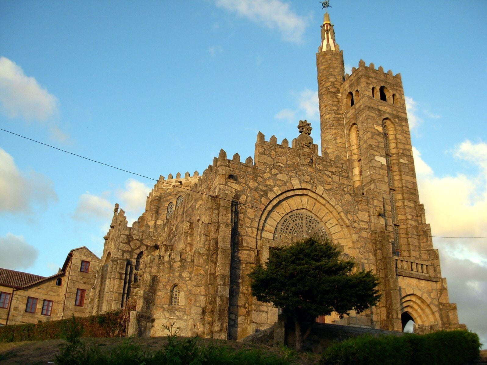 A historic stone cathedral with a tall bell tower and arched windows.