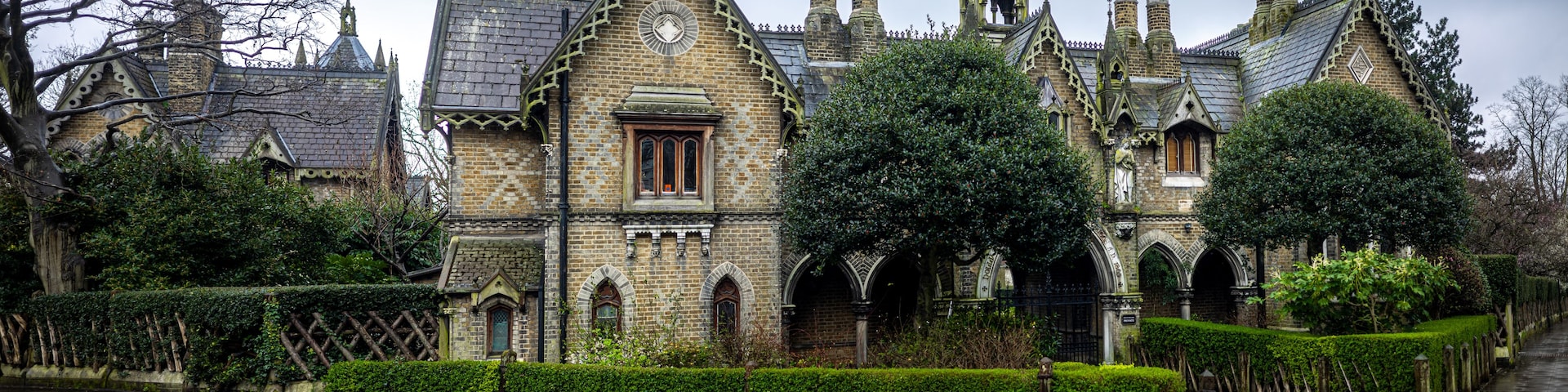 A historic building with Gothic architecture, including pointed arches and a clock tower.