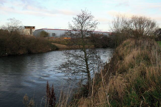 The River Derwent passes Pride Park. With an aggregate plant and Costco warehouse on the other bank.