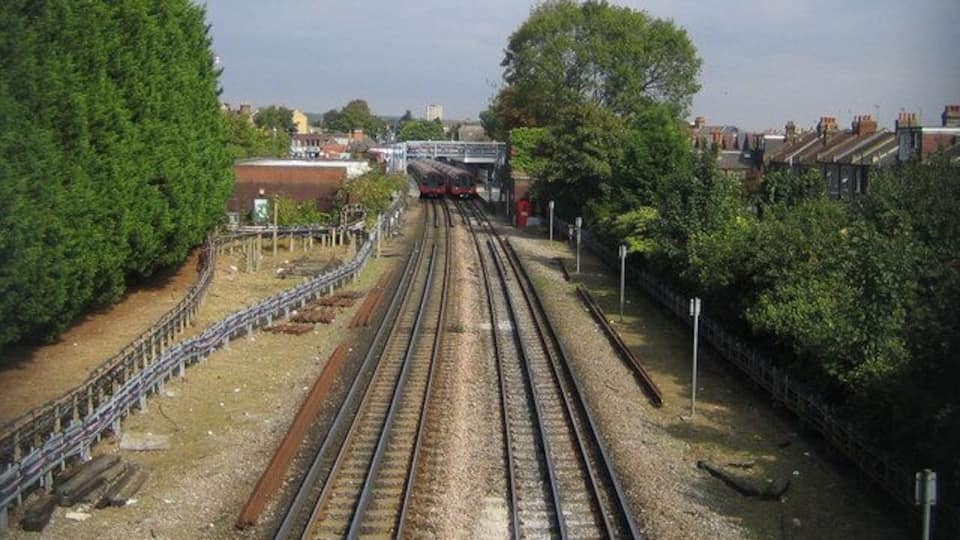 Central Line railway in South Woodford Northbound and southbound trains stopped in South Woodford station are visible in this view from the footbridge between Marlborough and Pulteney Roads.