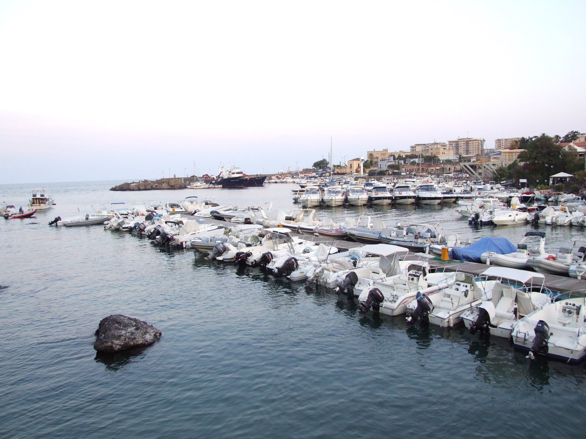 Porto Ulisse di Ognina it.wikipedia.org/wiki/Porto_Ulisse Il porto Ulisse è il porticciolo di Ognina, borgata periferica della città di Catania, posto alle coordinate 37° 31',53 Nord e 15° 07',27 Est. Il porto Ulisse si trova sulla costa nord della città di Catania ricavato da un'insenatura nella scogliera rocciosa; era un approdo portuale di Catania sin dall'antichità. Nell'area ove sorge il porto attuale sfociava un fiume il Lognina od Ognina che venne seppellito da una colata lavica dell'Etna in epoca medioevale. Nel 1381 il borgo di Ognina venne interamente sepolto da una colata di lava e dell'approdo rimase solo una piccola insenatura, quella attuale. Nel porto era presente anche una fiorente attività cantieristica i cui mastri d'ascia erano conosciuti ed apprezzati. Da porto da pesca nel dopoguerra si è lentamente attrezzato come porto turistico ed oggi offre servizi ed assistenza specializzati. Il porto si trova circa 3 miglia a nord-est del Porto di Catania ed è protetto da un molo foraneo di oltre 150 m con faro rosso di segnalazione sulla testata, un molo interno più piccolo e vari pontili galleggianti. I fondali vanno da 1,5 a 12 metri di profondità e sono fangosi nella parte più interna e rocciosi verso l'esterno. Il porto è attrezzato con rifornimento di carburante ed acqua, cantieri navali e quattro gru di alaggio. Vi hanno sede diversi Club nautici.