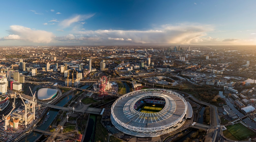 Stadsgezicht met een groot stadion, bruggen en wolkenkrabbers.