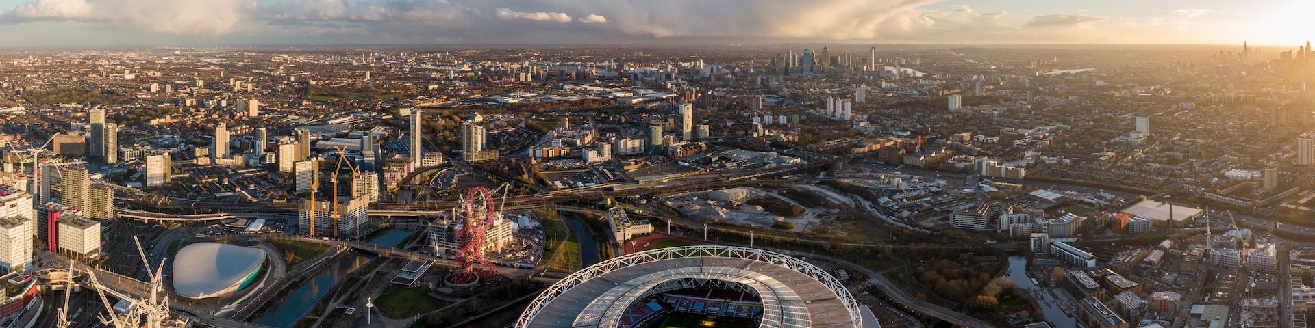 Paisagem urbana com um estádio grande, pontes e arranha-céus.