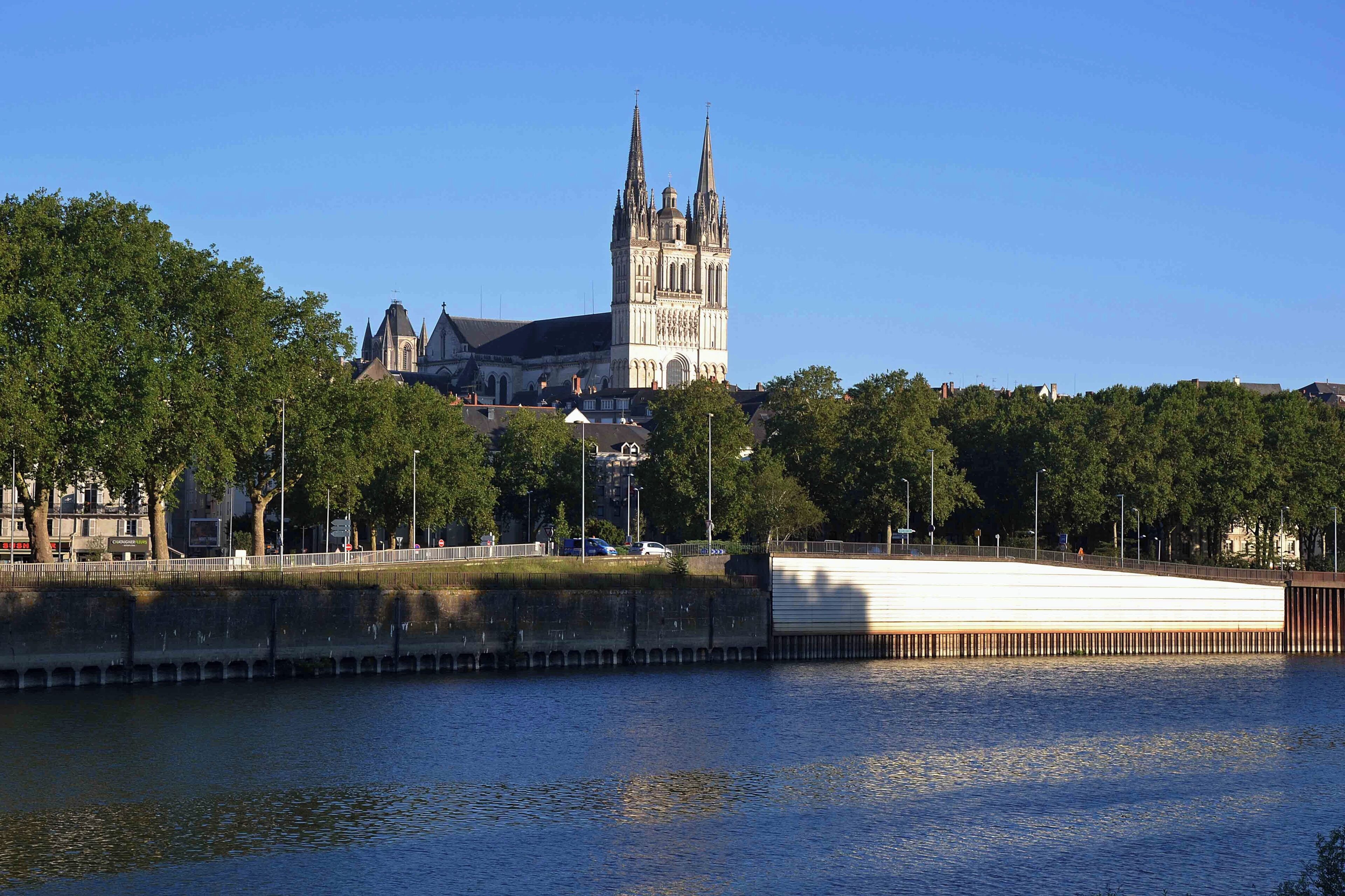 Una catedral con dos torres gemelas, un río y un puente.