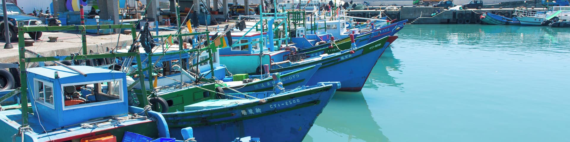 A harbor with several blue boats docked at the pier.